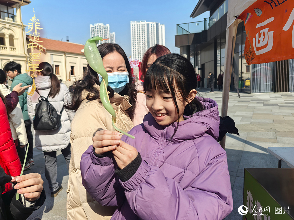 2025年1月29日，湖北武漢的新春廟會上，小朋友拿著吹制好的糖人，十分開心。人民網(wǎng)記者 張沛攝
