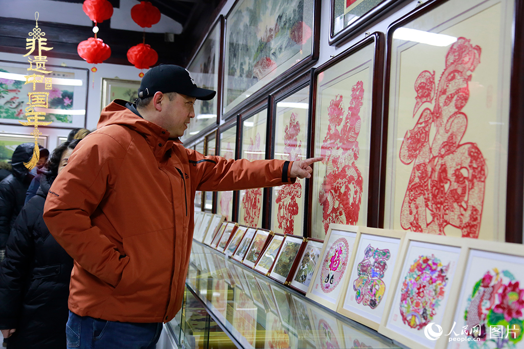 2025年1月23日，游客在天津楊柳青古鎮(zhèn)欣賞傳統(tǒng)剪紙作品，感受指尖上的古老藝術(shù)。人民網(wǎng)記者 崔新耀攝